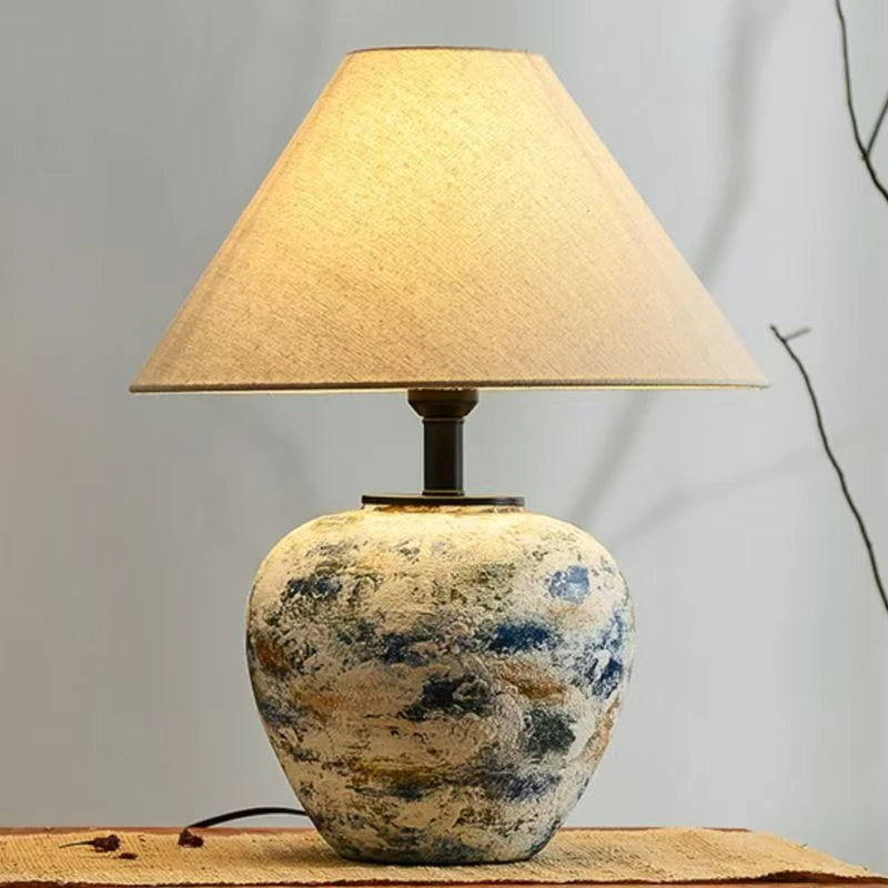 Lampe à poser céramique allumée sur un meuble