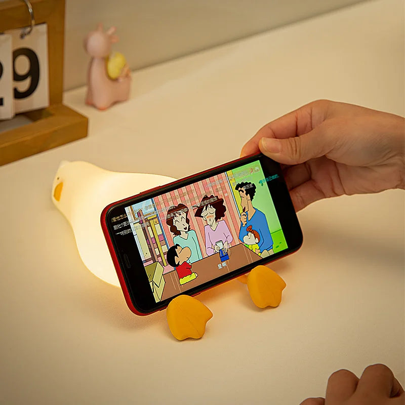 Veilleuse canard allongé cale un portable