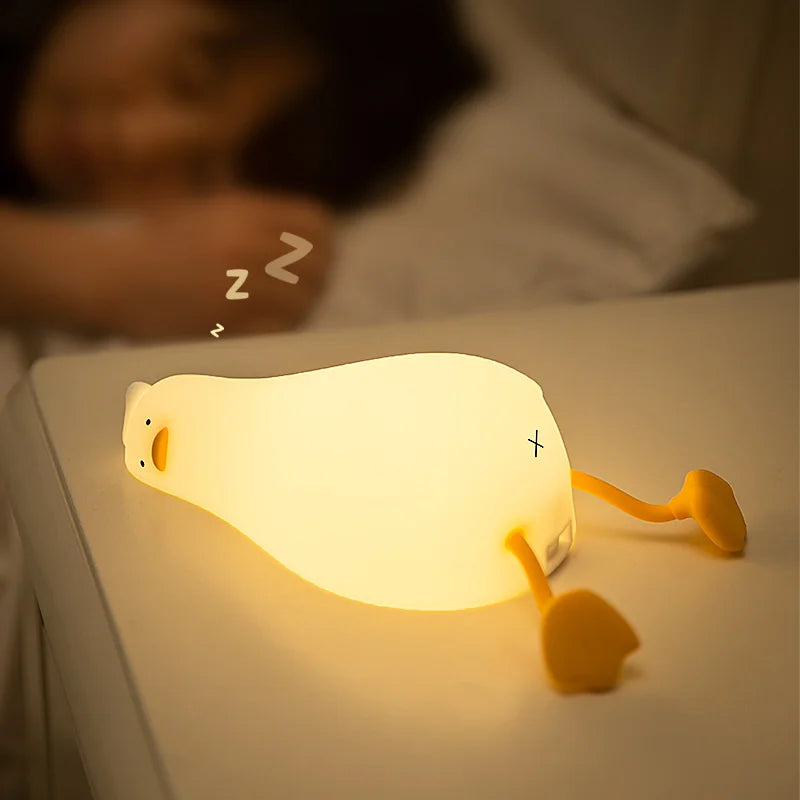 Veilleuse canard allongé sur une table de chevet