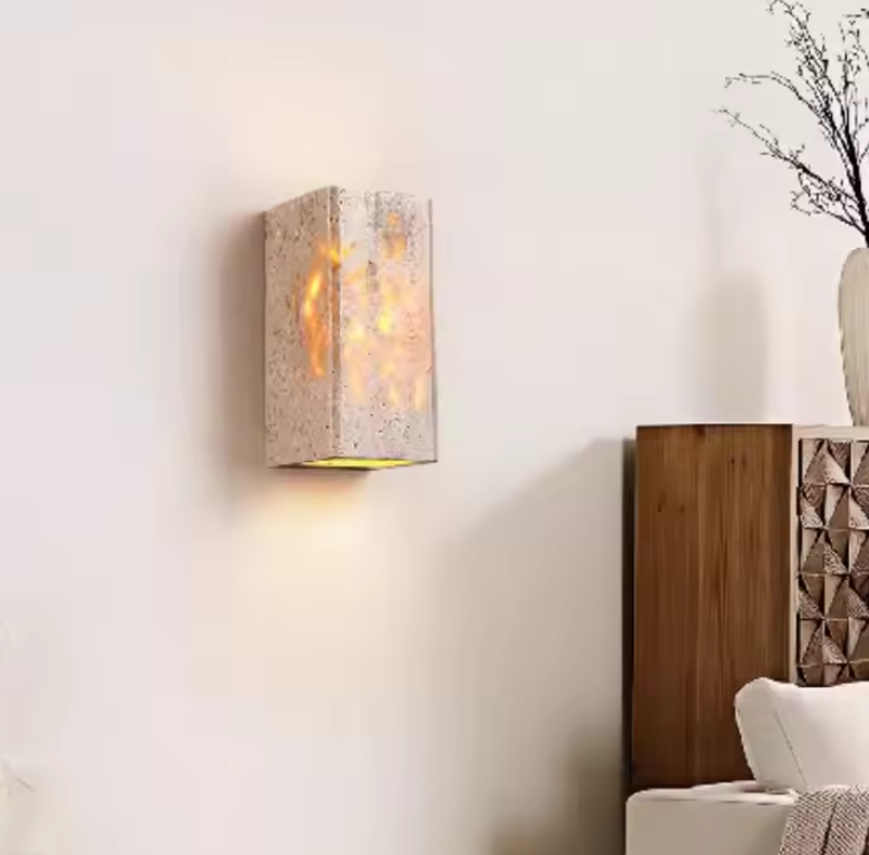 Applique murale cylindrique en pierre un meuble marron et un vase 