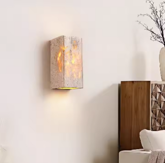 Applique murale cylindrique en pierre un meuble marron et un vase 