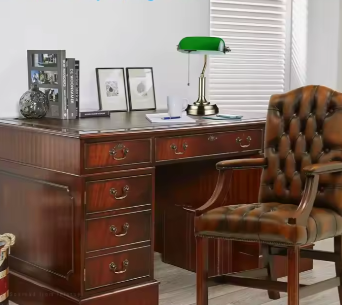 Lampe à poser abat-jour en verre vert sur un bureau et chaise en cuir 