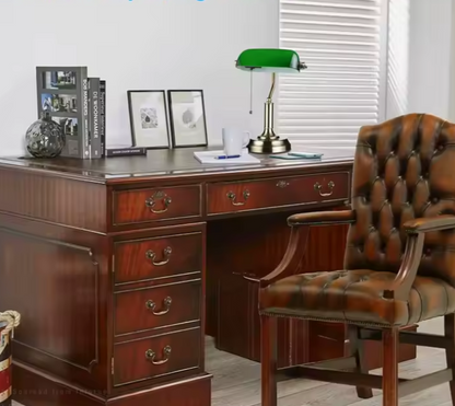 Lampe à poser abat-jour en verre vert sur un bureau et chaise en cuir 