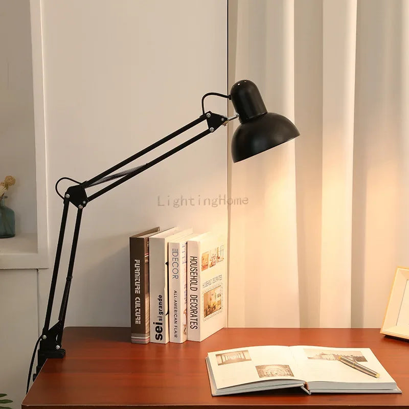 Lampe de bureau bras Long pliant allumé sur un bureau et un livre ouvert 