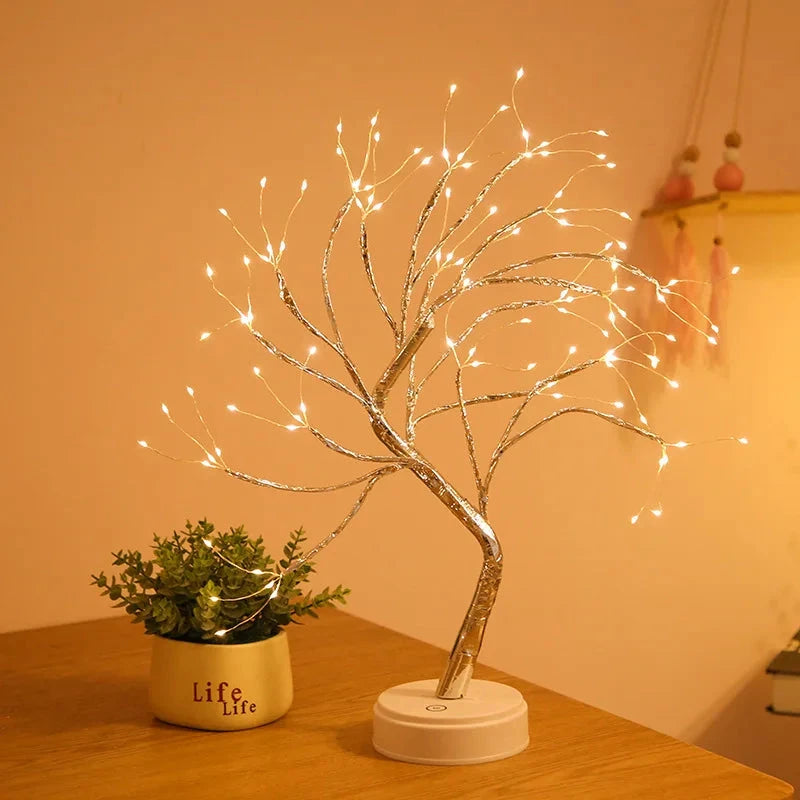   Lampe de chevet arbre féerique allumé sur table et plante 