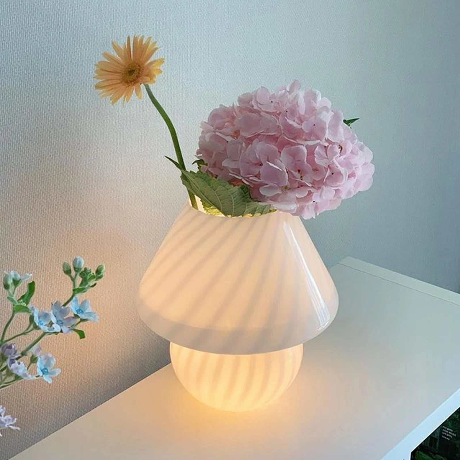Lampe de chevet champignon en verre allumé et des fleurs 