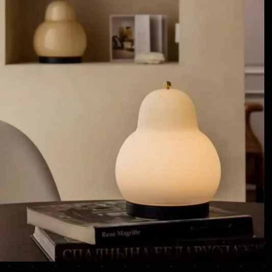 Lampe de chevet forme de poire allumée et livres 