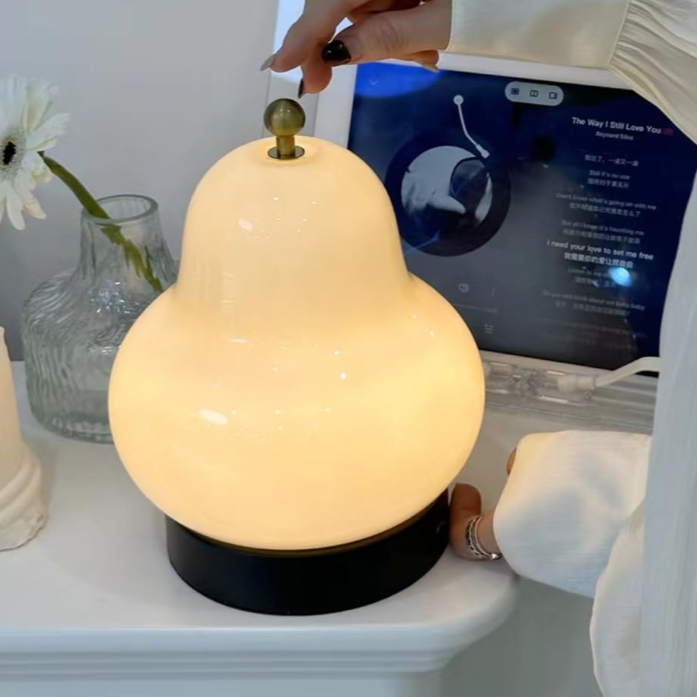 Lampe de chevet forme de poire allumée par une main     