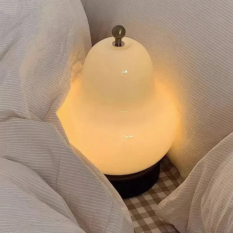 Lampe de chevet crème forme sur un lit 