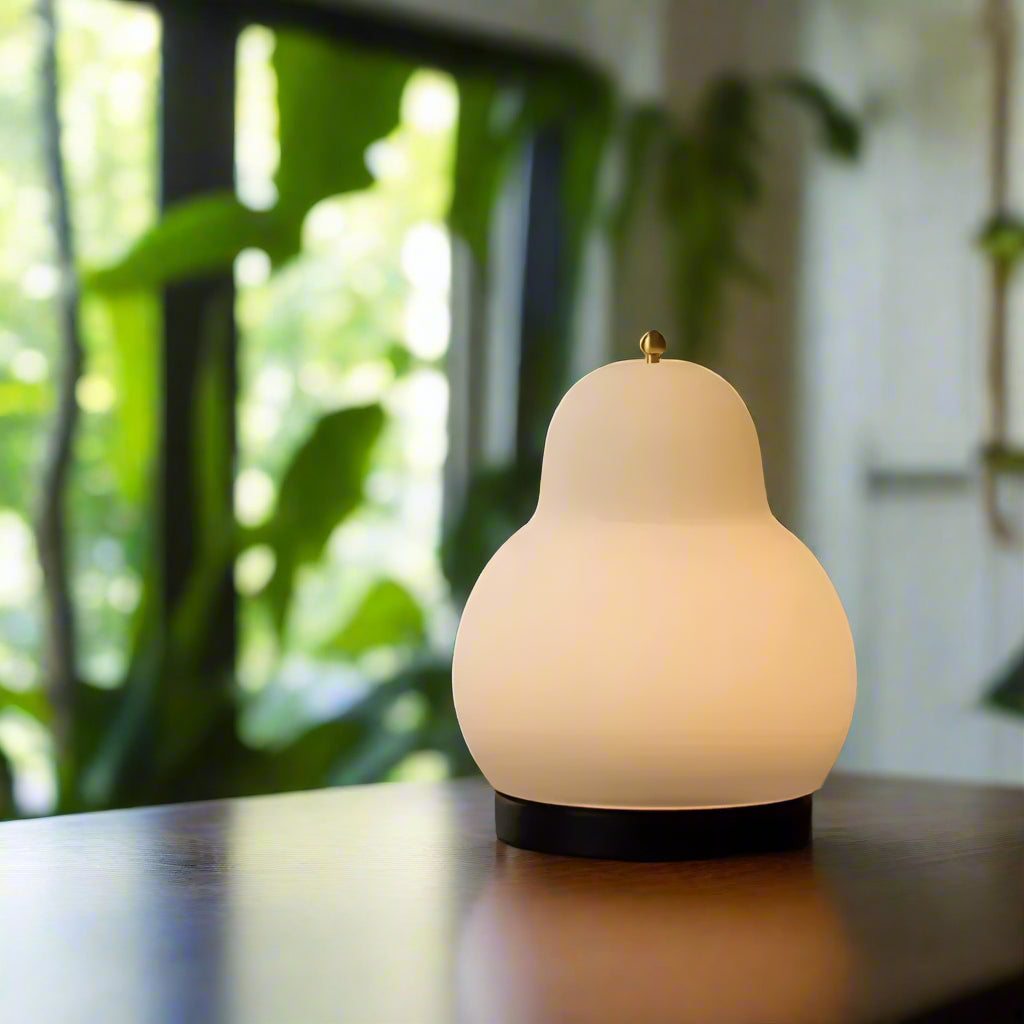 Lampe de chevet crème forme de poire sur une table et plate 