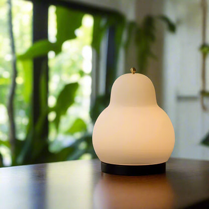 Lampe de chevet crème forme de poire sur une table et plate 