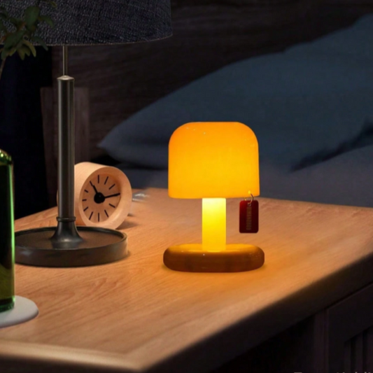 Lampe de chevet miniature allumé sur une table de chevet et un réveil 