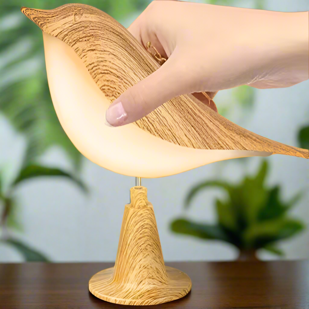 Lampe de chevet originale en forme d’oiseau porté par une main 