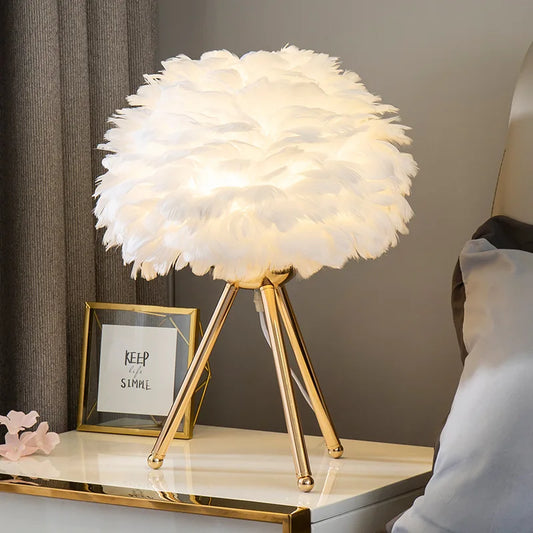 Lampe de chevet plumes allumée sur table de chevet 