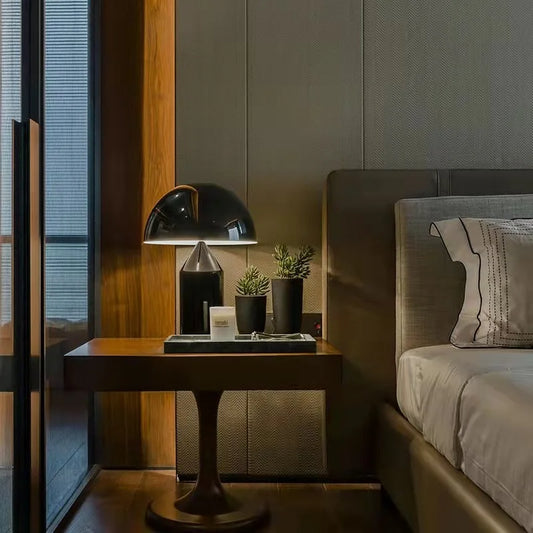 Lampe de table au style minimaliste sur table de chevet et lit 

