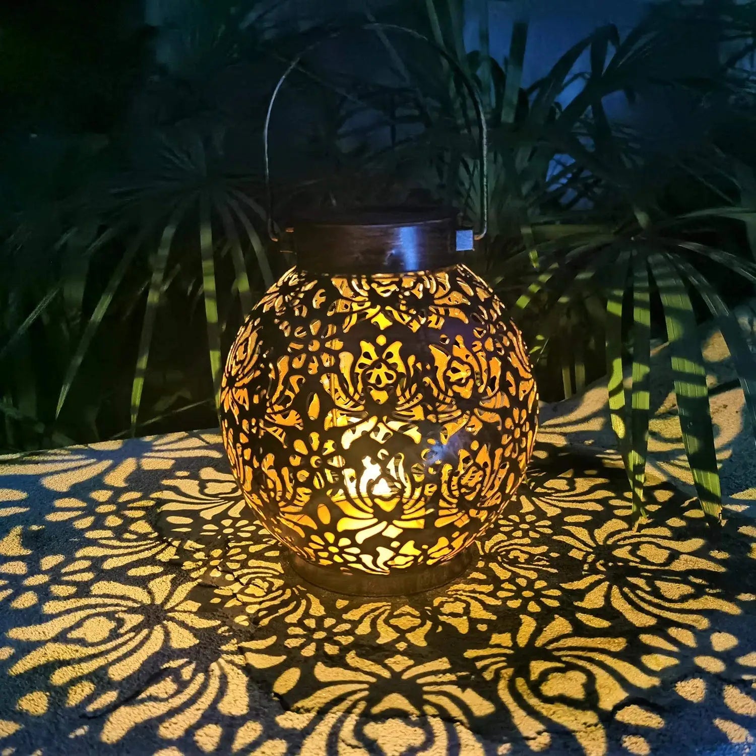  Lanterne solaire à motif au milieu des plantes de jardin 