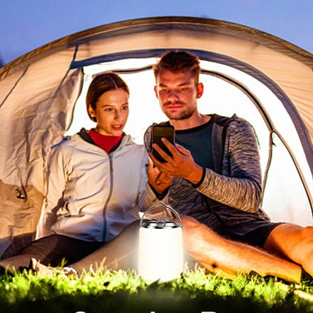Un homme et une femme sous la tente avec lampe de table rechargeable  