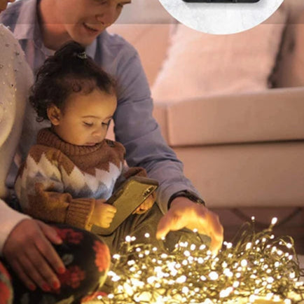 Un père et son bebe autour de guirlande lumineuse extérieur féerique 