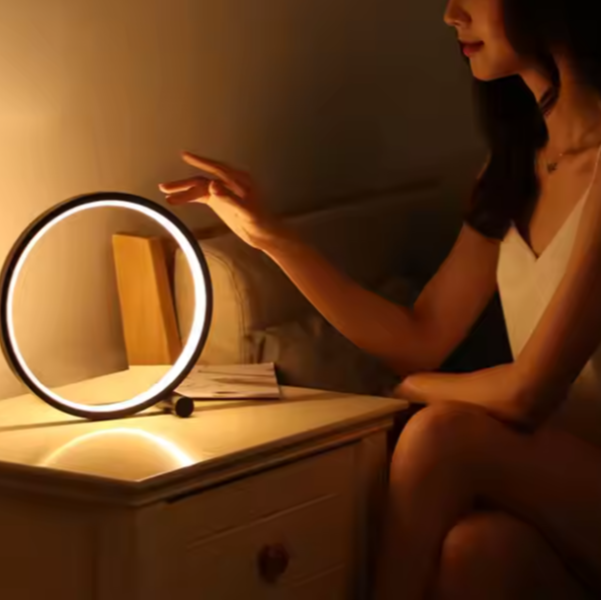 Une femme sur le lit et lampe de chevet circulaire 