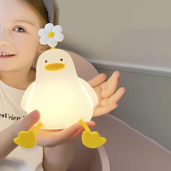 Une fille qui joue avec veilleuse LED canard  