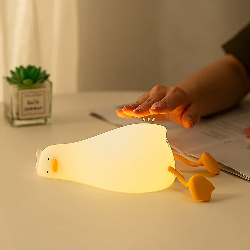 Une main qui appuie sur Veilleuse canard allongé  