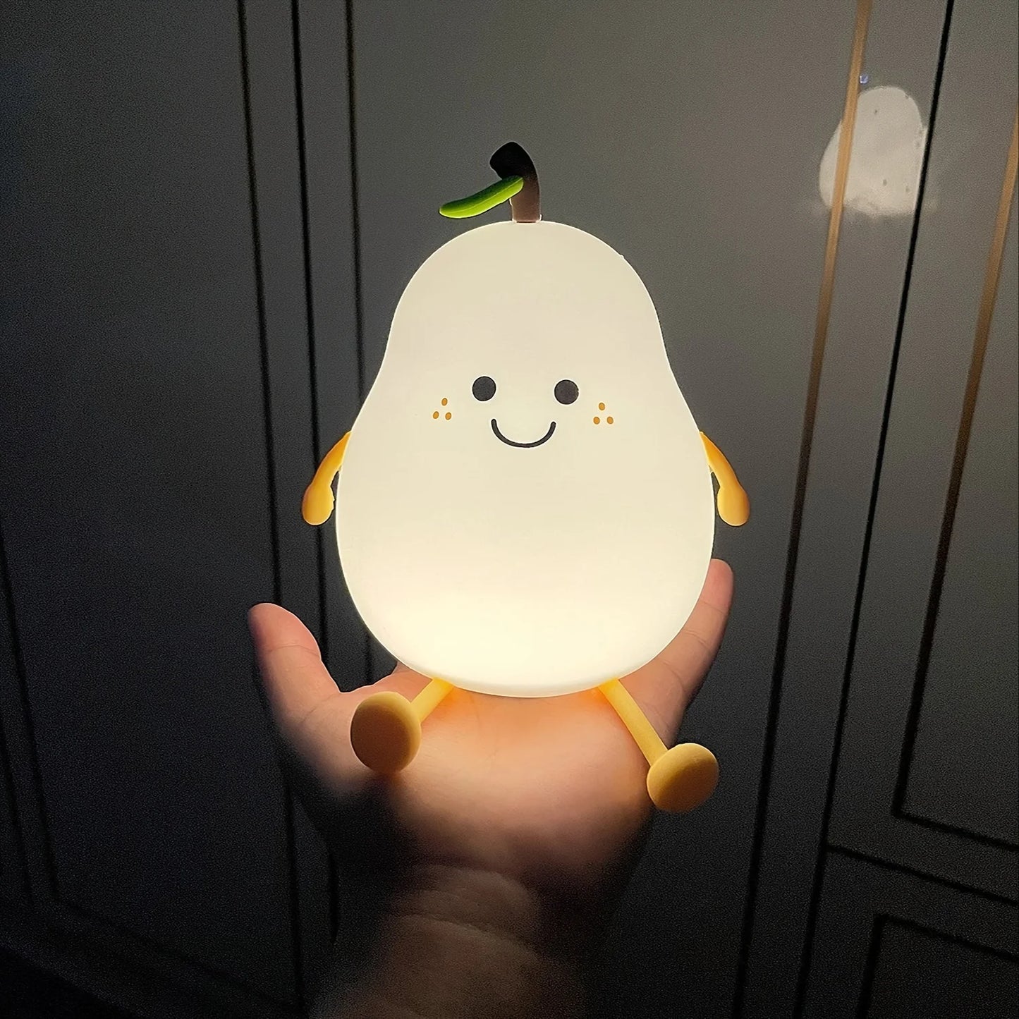 Une main qui porte veilleuse de nuit en forme de poire 