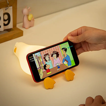 Veilleuse canard allongé cale un portable 