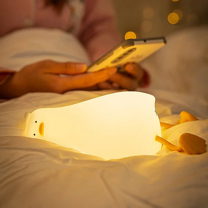 Veilleuse canard allongé sur un lit 